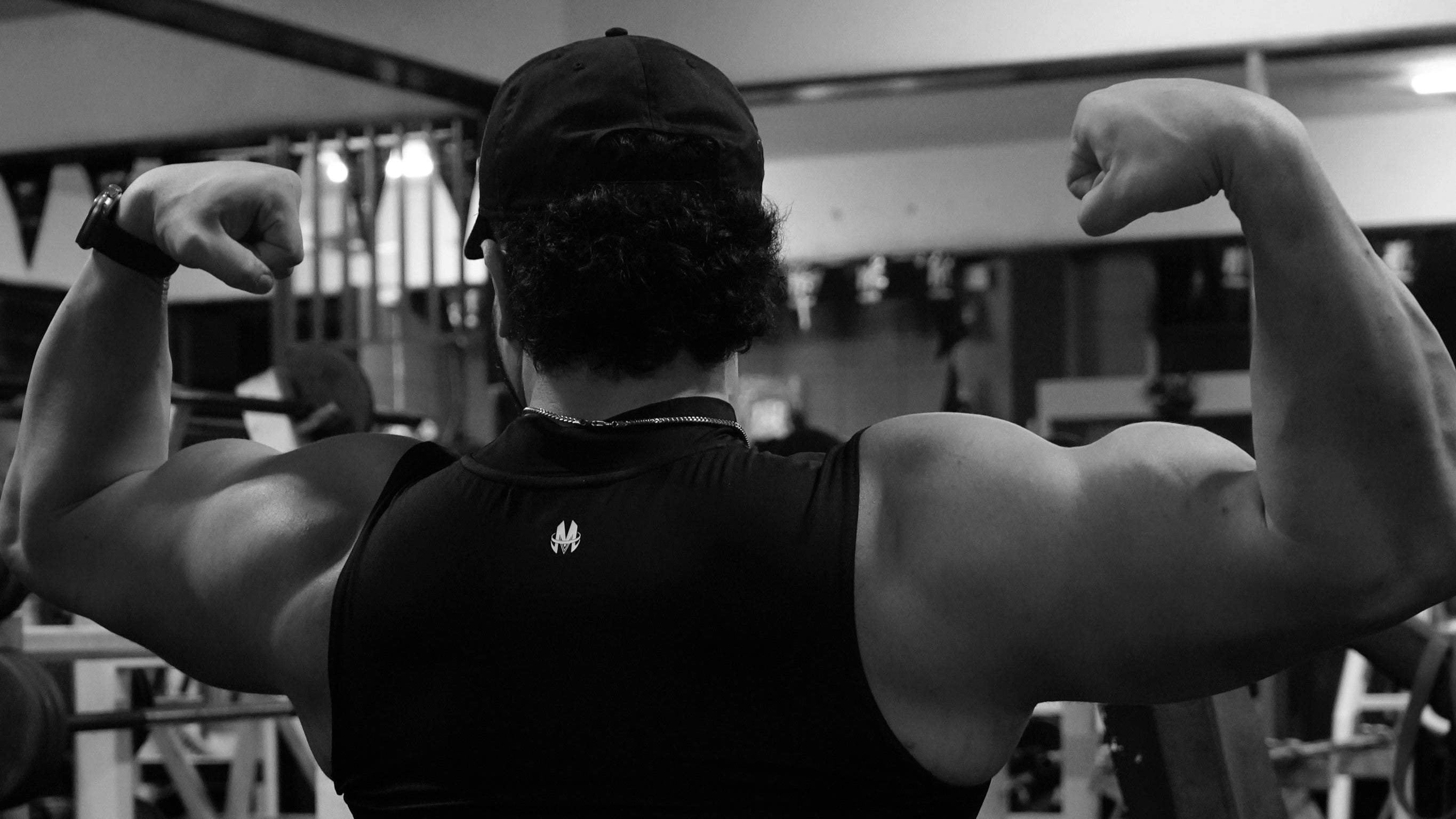 Person flexing muscles in a gym setting